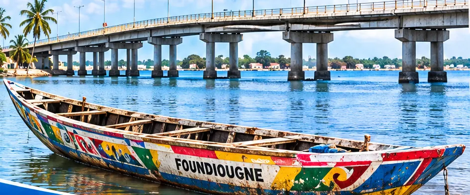 Pirogue peinte « Foundiougne » amarrée sur le Saloum, devant le pont
